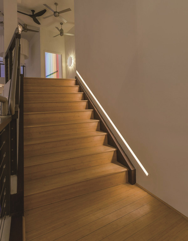 Installed into the wall beside the stairs at an angle to provide indirect, glare-free illumination