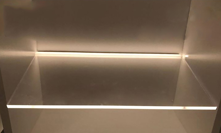 The LED strip aluminum channels installed on the edge of transparent acrylic panels for shelf lighting